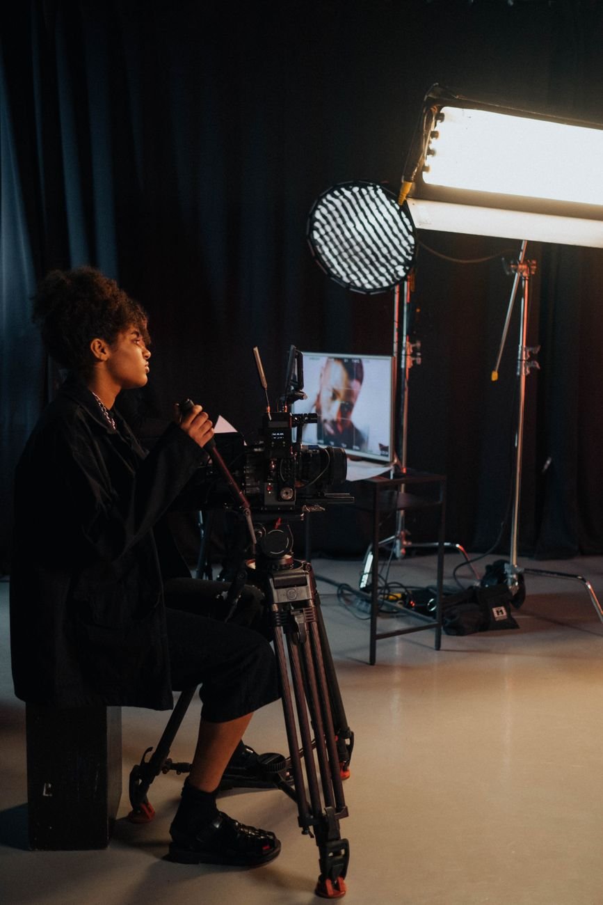 Videographer in dark studio at camera — the DemoReel production environment